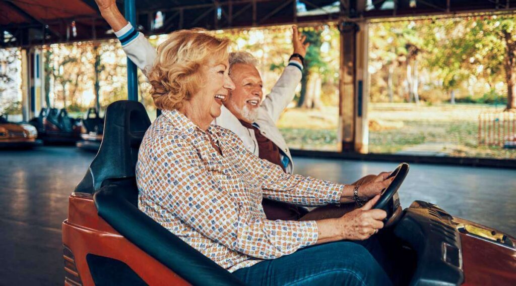 Mature couple enjoying themselves at a themepark after setting up life insurance in retirement